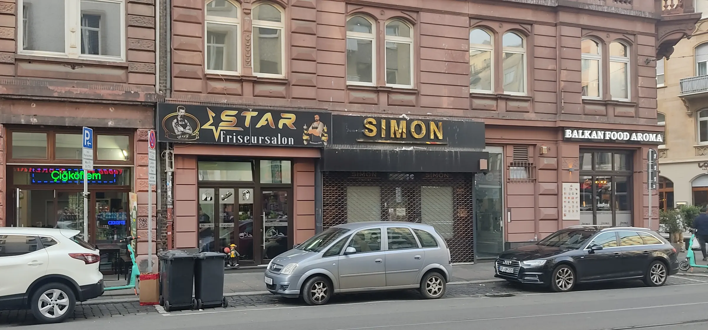 Hausfassade aus rotem Sandstein in der Münchener Straße mit dem Ladenschild STAR Friseursalon
